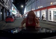 Woman Stands in Front of Car in Bugis, Leans on Bonnet as Driver Waits Inside Woman leaning on car bonnet in Bugis dashcam still