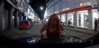 Woman leaning on car bonnet in Bugis dashcam still