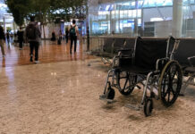 An empty wheelchair in a Singapore airport terminal departure hall
