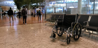 An empty wheelchair in a Singapore airport terminal departure hall
