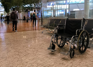 An empty wheelchair in a Singapore airport terminal departure hall