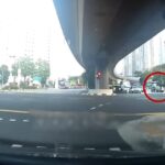 Dashcam still of a pedestrian with an umbrella crossing a Clementi junction