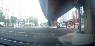 Dashcam still of a pedestrian with an umbrella crossing a Clementi junction
