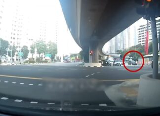 Dashcam still of a pedestrian with an umbrella crossing a Clementi junction