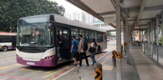 Commuters boarding a public bus at a Singapore bus interchange