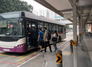 Commuters boarding a public bus at a Singapore bus interchange