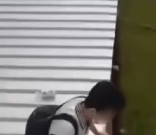 Hua Yi Secondary student sitting on a temporary metal walkway roof