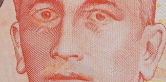 Close-up of a genuine S$10 note with Yusof Ishak moustache scraped off and eyelids scratched