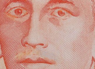 Close-up of a genuine S$10 note with Yusof Ishak moustache scraped off and eyelids scratched
