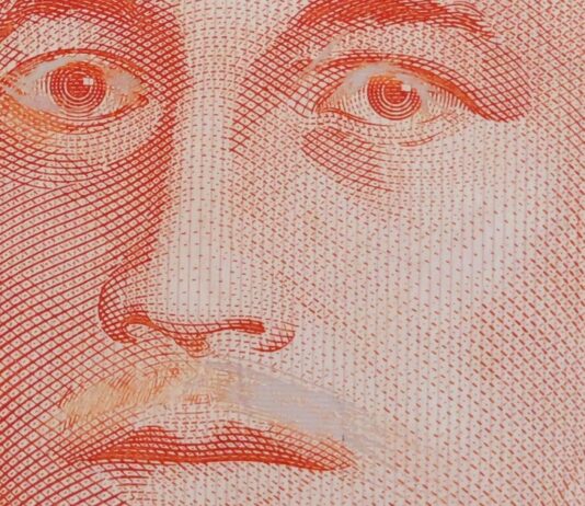 Close-up of a genuine S$10 note with Yusof Ishak moustache scraped off and eyelids scratched