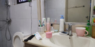 A typical Singapore bathroom vanity with an unlabelled pink facial cream jar among everyday toiletries