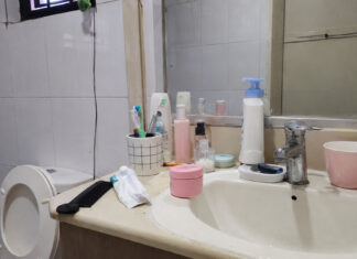 A typical Singapore bathroom vanity with an unlabelled pink facial cream jar among everyday toiletries
