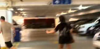 Video still of women confronting a man behind an HDB pillar in Sengkang