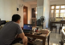 A person watching videos on a laptop in a Singapore HDB living room