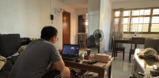 A person watching videos on a laptop in a Singapore HDB living room