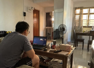 A person watching videos on a laptop in a Singapore HDB living room