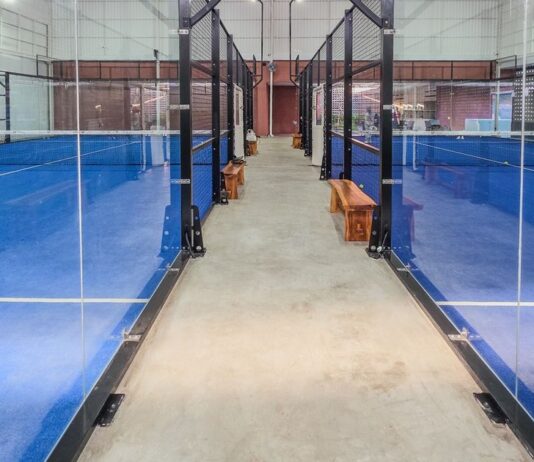 Singapore Man Says He Put S$368,000 Into Indonesian Sports-Gear Business and Fears Losing S$157,000 Empty indoor padel courts with blue turf and glass walls, non-literal stock for a sports-gear investment dispute