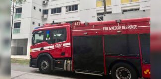 Red SCDF fire engine marked FIRE & RESCUE RESPONSE parked outside an HDB block after a residential fire response