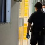 Police officers at open unit doorway along HDB corridor in Ubi for elderly man found dead alone story