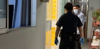 Police officers at open unit doorway along HDB corridor in Ubi for elderly man found dead alone story