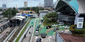Cars and motorcycles queuing at Bangunan Sultan Iskandar Johor Bahru CIQ on the Causeway approach for foreign-vehicle entry toward Singapore