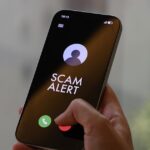 At Least S$4.8 Million Lost to Scammers Posing as Harvey Norman Staff; 119 Cases Since January Hand holding a smartphone showing a SCAM ALERT incoming-call screen for a Harvey Norman impersonation scam advisory