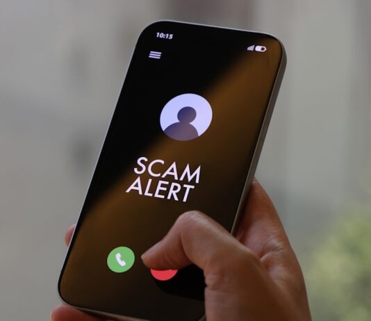 At Least S$4.8 Million Lost to Scammers Posing as Harvey Norman Staff; 119 Cases Since January Hand holding a smartphone showing a SCAM ALERT incoming-call screen for a Harvey Norman impersonation scam advisory