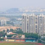 Hazy view over a Singapore neighbourhood sports field and HDB blocks
