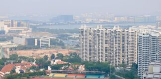 Hazy view over a Singapore neighbourhood sports field and HDB blocks