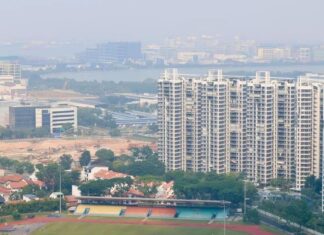 Hazy view over a Singapore neighbourhood sports field and HDB blocks