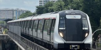 Singapore MRT train on elevated track with residential blocks behind
