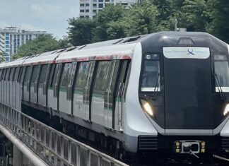 Singapore MRT train on elevated track with residential blocks behind