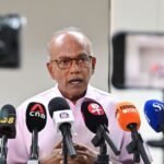 Senior Minister K Shanmugam speaking at a media doorstop after directing police to investigate racist online comments