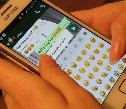 Person using a smartphone messaging app, illustrating a WhatsApp impersonation scam warning