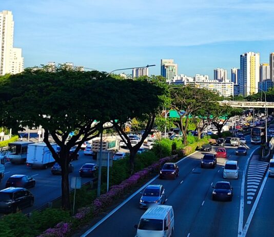 Illustrative photo of weekday traffic on the Pan Island Expressway in Singapore, with HDB and condo blocks in the background; number plates blurred (Photo: ZKang123 / Wikimedia Commons, CC BY-SA 4.0)