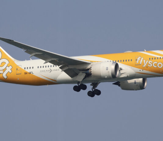 Scoot Boeing 787 Dreamliner in yellow livery flying in the air