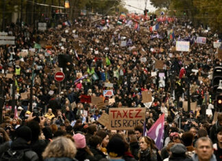 France Protests Turn Violent; Louvre & Over 20 Paris Metro Stations Closed on Saturday Large crowd of demonstrators marching through a Paris street