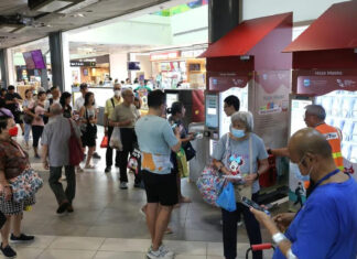 Seniors queueing at haze mask vending machines in a Singapore shopping area