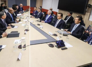 Officials seated around a long conference table at a meeting