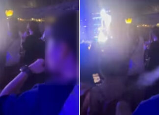 Blurry concert crowd with a person in a purple-lit venue