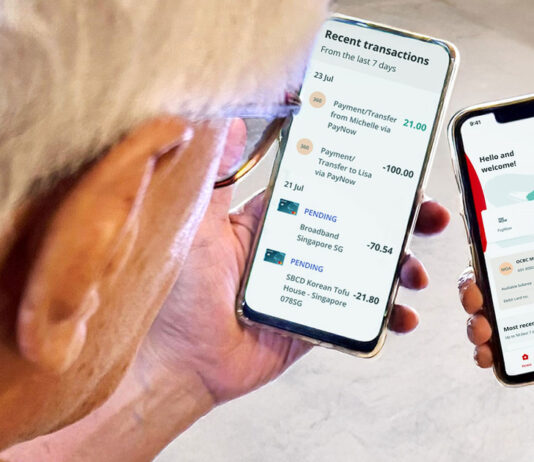 Two smartphones showing the OCBC banking app held in hands