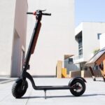 Parliament Passes Online Sales Ban for Non-Compliant Mobility Devices & New Battery Safety Rules Illustrative photo of an electric kick scooter with a battery pack on its stem, standing in an empty paved plaza (Photo: Claybox / Wikimedia Commons, CC BY-SA 4.0)