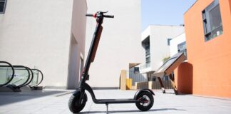 Illustrative photo of an electric kick scooter with a battery pack on its stem, standing in an empty paved plaza (Photo: Claybox / Wikimedia Commons, CC BY-SA 4.0)