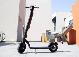 Illustrative photo of an electric kick scooter with a battery pack on its stem, standing in an empty paved plaza (Photo: Claybox / Wikimedia Commons, CC BY-SA 4.0)