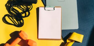 Blank clipboard beside dumbbells, a skipping rope and a resistance band, illustrating prepaid fitness packages