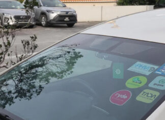 Private-hire car windscreen with PHC decals and ride-hailing stickers