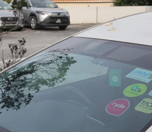 Private-hire car windscreen with PHC decals and ride-hailing stickers