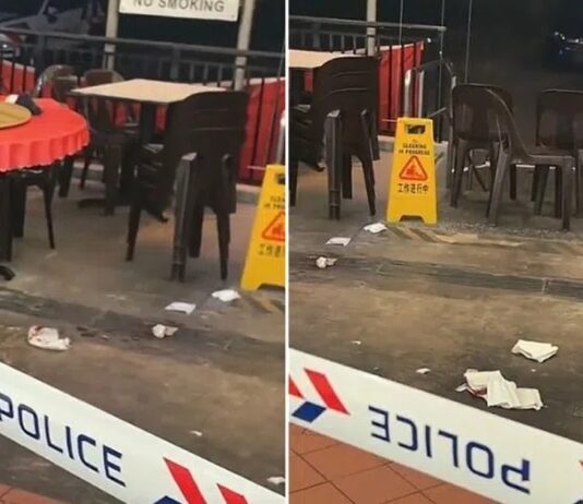 73-Year-Old Man Dies, Another Injured in Telok Blangah Heights Incident; 32-Year-Old Man Arrested Police tape cordoning off the ground-floor coffee shop near Block 61 Telok Blangah Heights, with empty tables and tissues on the floor (Photo: TikTok/itsmarvin via Lianhe Zaobao)