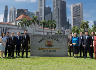 Workers' Party MPs and members posing in front of the Parliament of Singapore sign